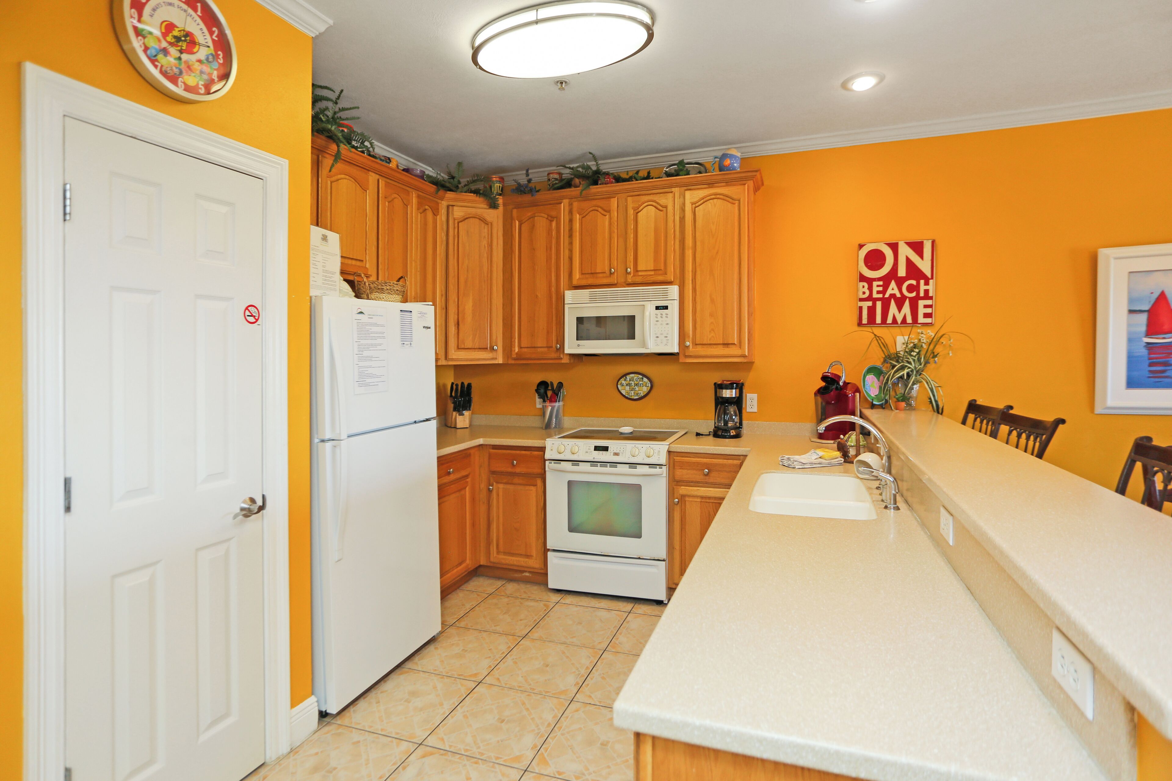 A kitchen with wooden cabinets, a white refrigerator, a microwave, and a stove.