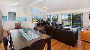 Een moderne keuken met een eetgedeelte, een bank en een balkon met uitzicht.