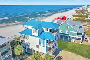 A beachfront property with multiple buildings, including a large house with a blue roof and a smaller structure with a red roof. - Private Pool, Beachfront, Elevator ~ Cape Destiny (Cape San Blas)