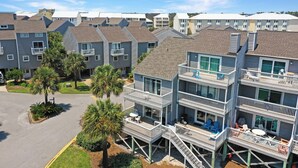 A multi-story residential building with balconies, outdoor seating, and a parking area. - Barrier Dunes, Cape San Blas, Community Pools/Tennis - BD 497 (Cape San Blas)