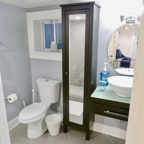 Un baño con inodoro, bidé y bañera. Hay un espejo sobre el lavabo y una ventana sobre el inodoro.