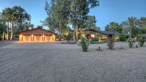 A residential property with a gravel driveway, a garage, and a house with a sloped roof. - Starfire GOLF VIEW, Heated POOL, TVs All BRs, Game Room w/Pool Table (Scottsdale)