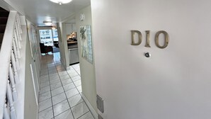 Ein Flur mit einer weißen Wand, auf der die Buchstaben "DIO" stehen, und einer Deckenleuchte.