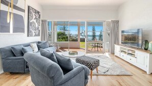 Ein modernes Wohnzimmer mit grauem Sofa, einem Couchtisch und einer TV-Konsole.