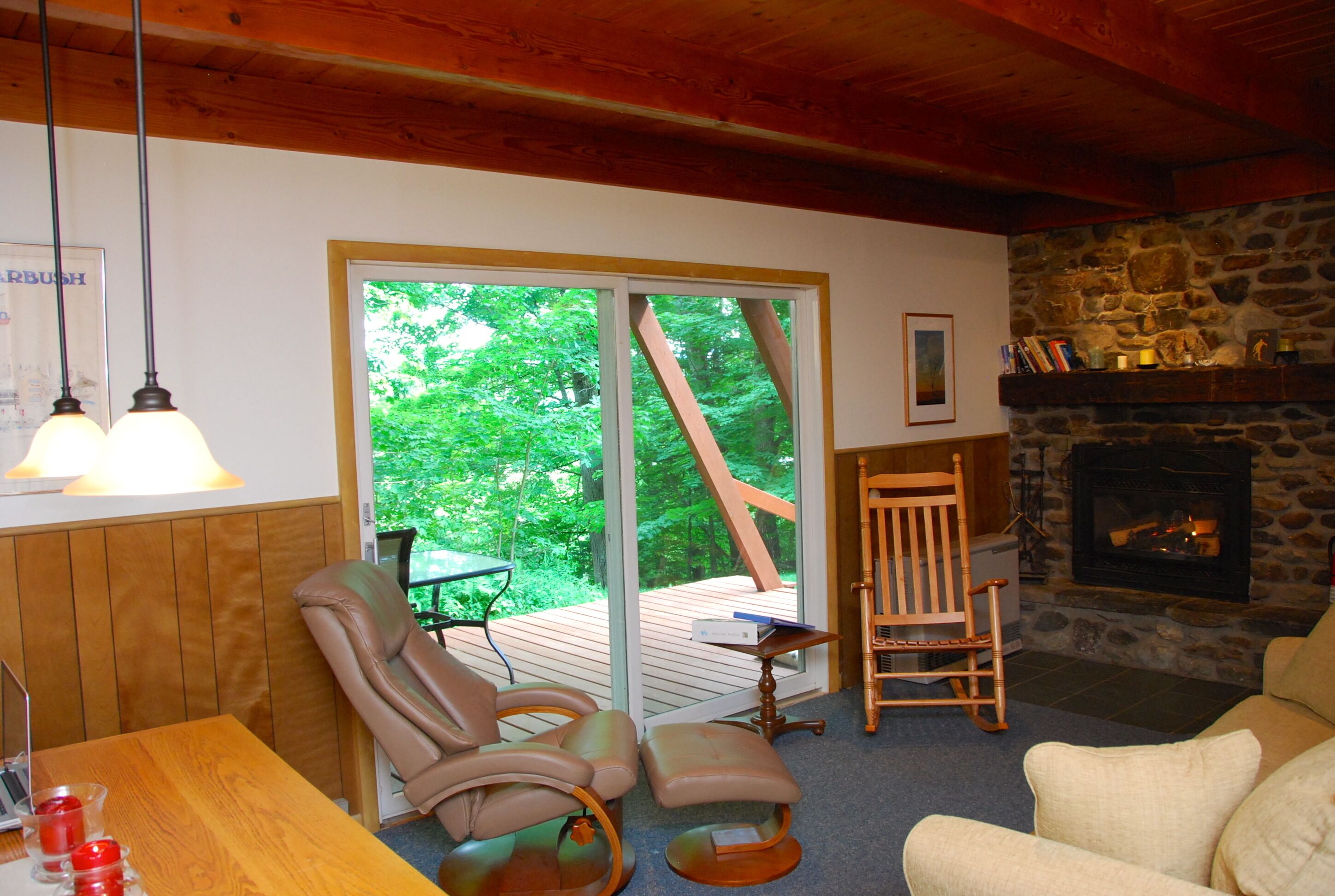 Living room with deck access and gas fireplace insert.
