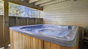 A hot tub with a wooden exterior and a view of trees through a window. - 32 Fairway Village-Sunriver, Oregon: Hot Tub, Pool in Complex, BBQ, WiFi, SHARC Aquatics, Tubing Hill, Mt. Bachelor, Golf, Deschutes River, Tennis, Bike Paths (Sunriver)