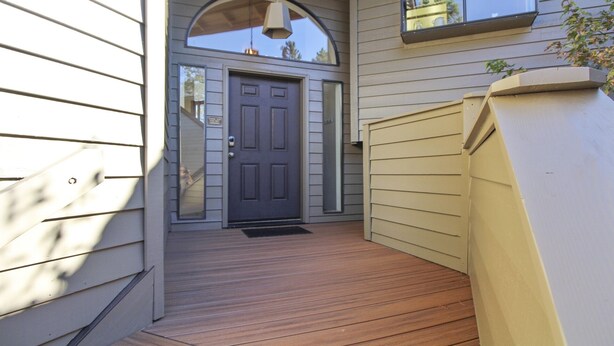 A wooden deck leading to a dark gray door with a small overhang above it. - 32 Fairway Village-Sunriver, Oregon: Hot Tub, Pool in Complex, BBQ, WiFi, SHARC Aquatics, Tubing Hill, Mt. Bachelor, Golf, Deschutes River, Tennis, Bike Paths (Sunriver)
