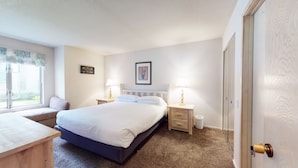 A bedroom with a bed, bedside tables, a window, and a door. - Snowcreek Resort Vacation Rental 611 (Mammoth Lakes)