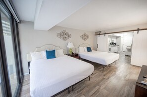 Une chambre d’hôtel avec deux lits, une grande fenêtre et vue sur la cuisine.
