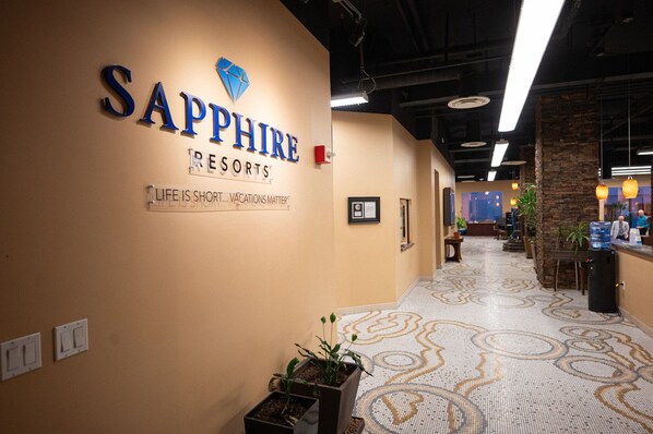 A corridor with a sign reading "Sapphire Resorts" and a motto "Life is short... vacations matter".