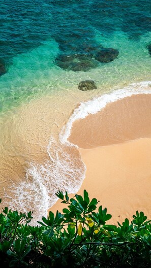 A beach with clear turquoise water and a sandy shore.