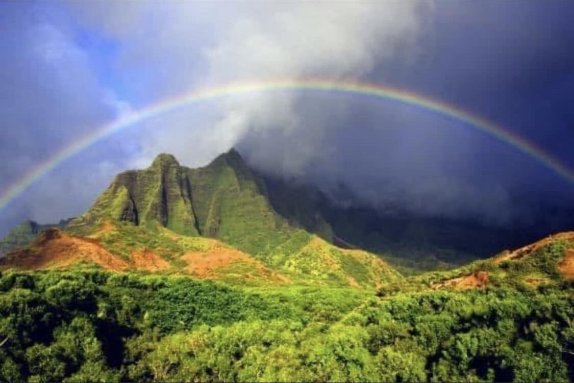 Un paisaje montañoso con un arcoíris.