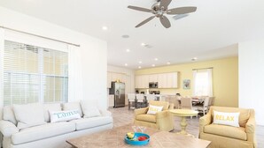 A spacious living area with a sofa, two armchairs, a coffee table, and a dining table.