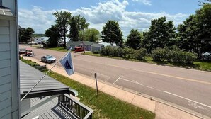 Una calle residencial con una bandera, casas y cielo despejado.