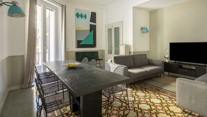 A modern living room with a dining table, sofa, and TV. - The bright, spacious apartment is located in Via Luigi Settembrini, on the 1st floor of an elegant Art Nouveau residential building with porter's lodge and elevator, from the early 20th century. During the most recent renovation work, some antique, elegan (Roma)