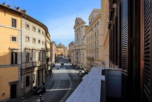 Straßenansicht mit historischen Gebäuden, blauem Himmel und einer Fußgängerampel.