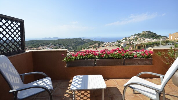 A balcony with two chairs and a table, overlooking a town with a hill and flowers in the foreground. - Holiday rental semidetached with swimming pool in Begur, Centre (Begur)