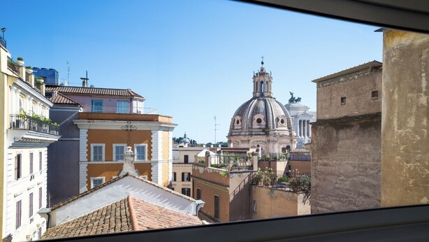 Una vista dello skyline urbano con edifici storici, una cupola imponente e cielo sereno.