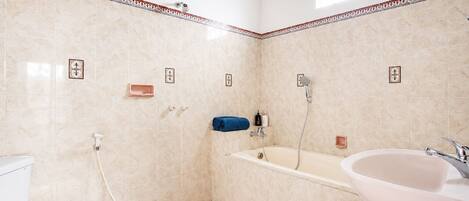A bathroom with a toilet, shower, and sink.