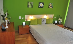 Cozy retreat with a green accent wall, a comfortable bed, and two bedside tables with lamps and decorative accents.