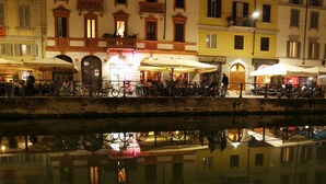 Une zone riveraine avec des bâtiments, des espaces de restauration en plein air et des vélos.