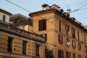 A multi-story building with traditional architecture, featuring balconies and a mix of window styles.