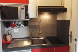 Une cuisine moderne équipée d’un évier en acier inoxydable, d’un four à micro-ondes et d’une cuisinière.
