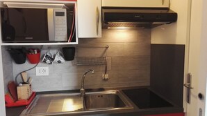 A modern kitchen with a stainless steel sink, a microwave, and a stove. - Nice and bright apartment with wi-fi and a/c in Darsena and Navigli district (Milano)