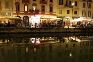 A waterfront area with buildings, outdoor seating, and bicycles.