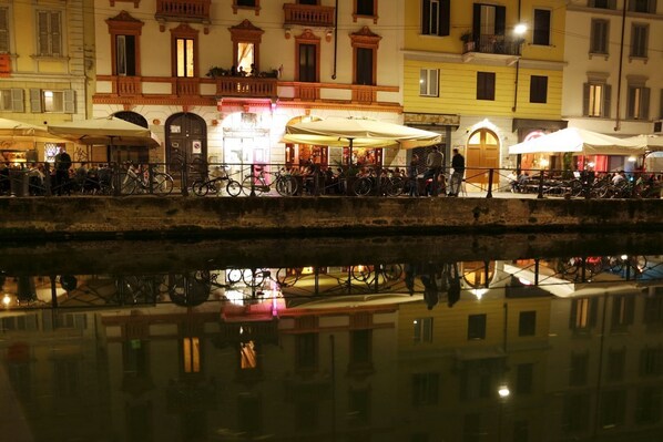 A waterfront area with buildings, outdoor seating, and bicycles.