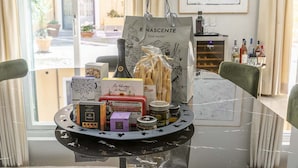 A dining table with a tray of food items and a shopping bag labeled "R Nascente food market". - FONTANELLA BORGHESE PALACE (Roma)