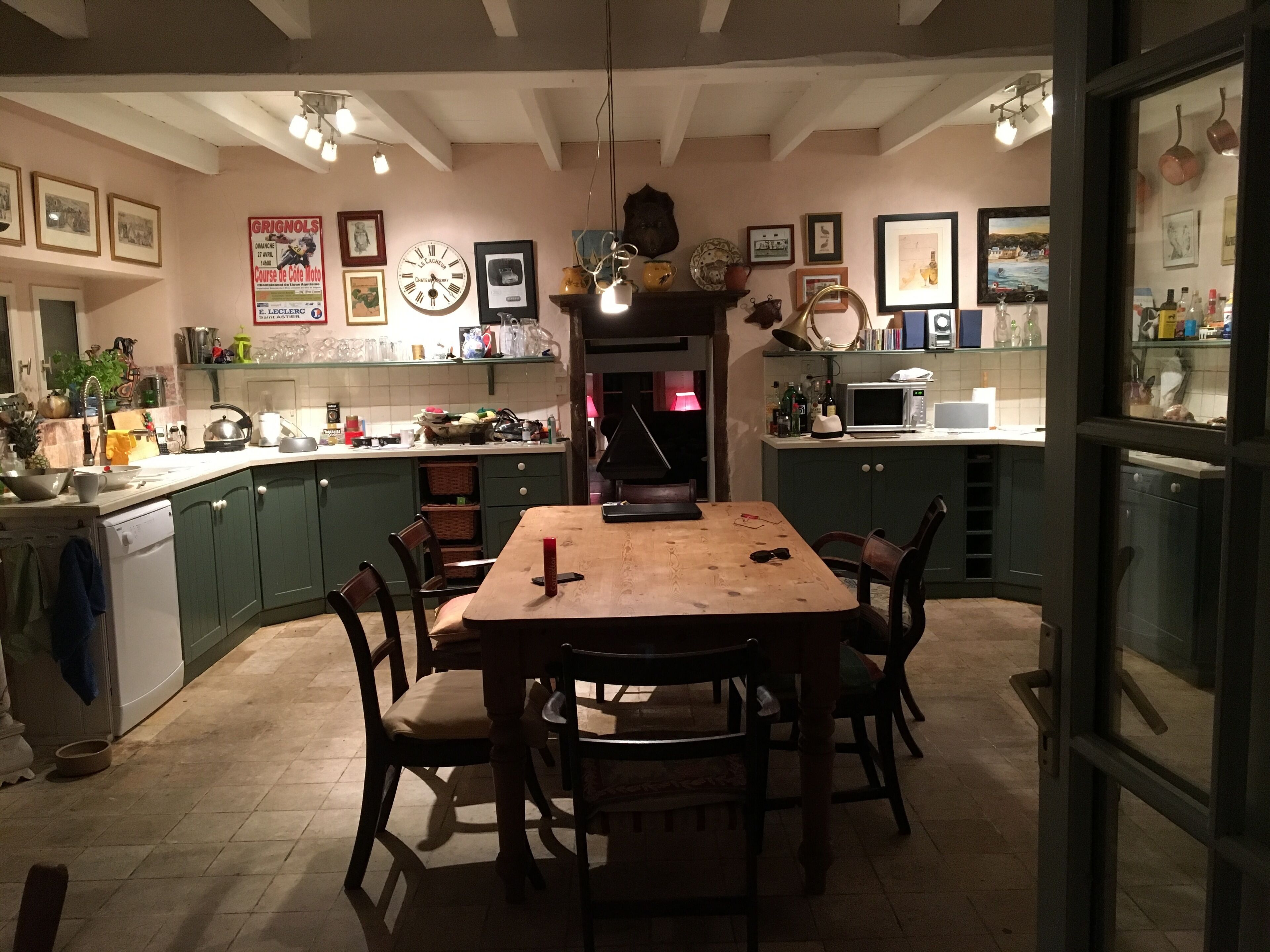Une cuisine chaleureuse avec une table en bois, des chaises et divers appareils de cuisine.