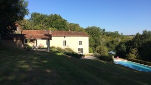 Una casa de dos pisos con piscina y jardín.