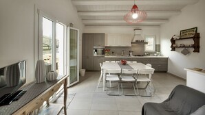 A modern kitchen with white cabinets, a dining table with chairs, and a red pendant light. - Piazza Salvatore, 7, rooms with a view (Ragusa)