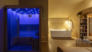 Ein moderner Spa-Raum mit Sauna, Badewanne und einer Holzterrasse.