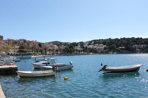 A marina with several boats docked, a clear blue sky, and buildings in the background. - Spacious Family Apartment With Pool (Cavtat)