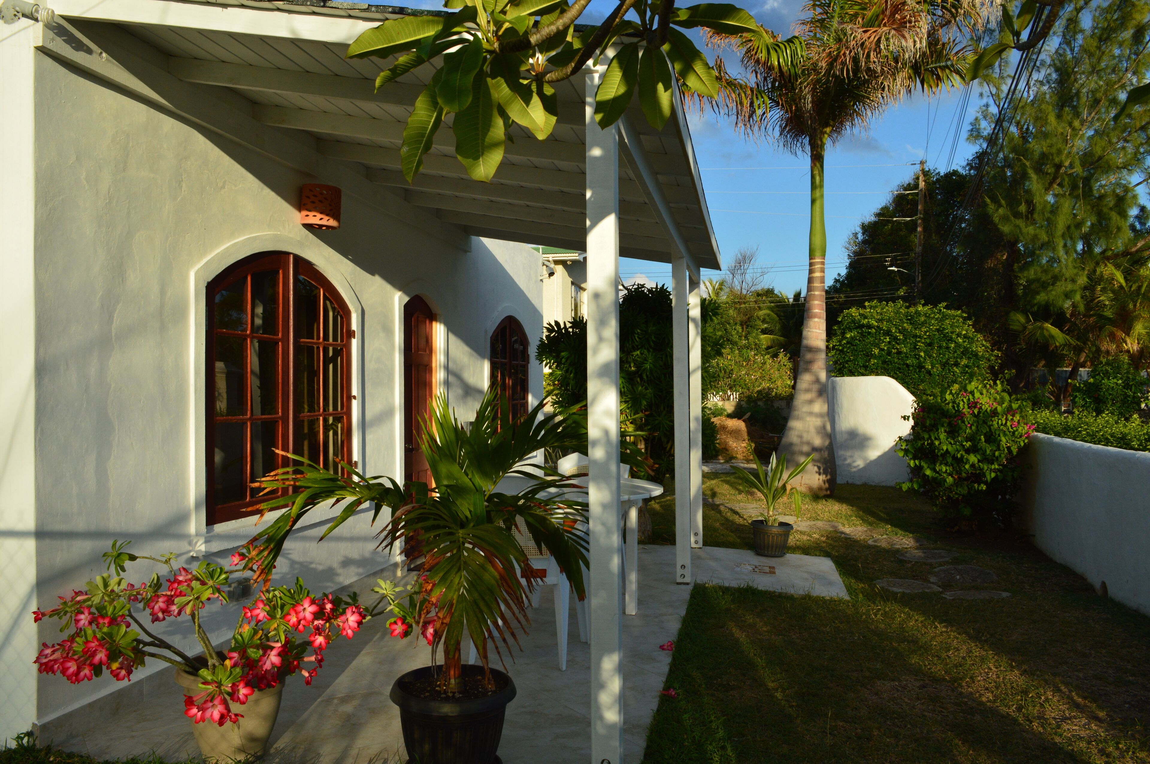 A white building with arched windows and a covered porch.