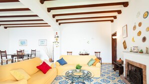 A living room with a yellow sofa, a round coffee table, and a fireplace. - Casa Annalu with sea view - My Rental Homes (Positano)