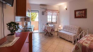 A compact living space with a kitchenette, a dining area, and a bedroom. - Studio with internet access, near the sea (Vrbnik)