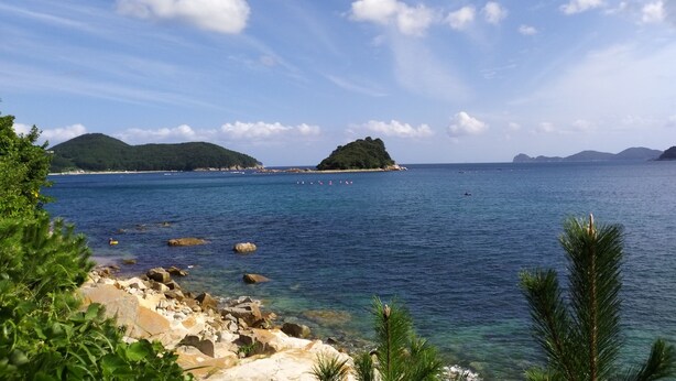 A coastal landscape with clear skies, rocky shoreline, and distant islands. - A day in Geoje Pension (Geoje)