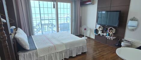 A hotel room with a bed, a TV, a desk, and a chair.
