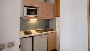 Een praktische keuken met een ingebouwde magnetron, een vaatwasser en een spoelbak.