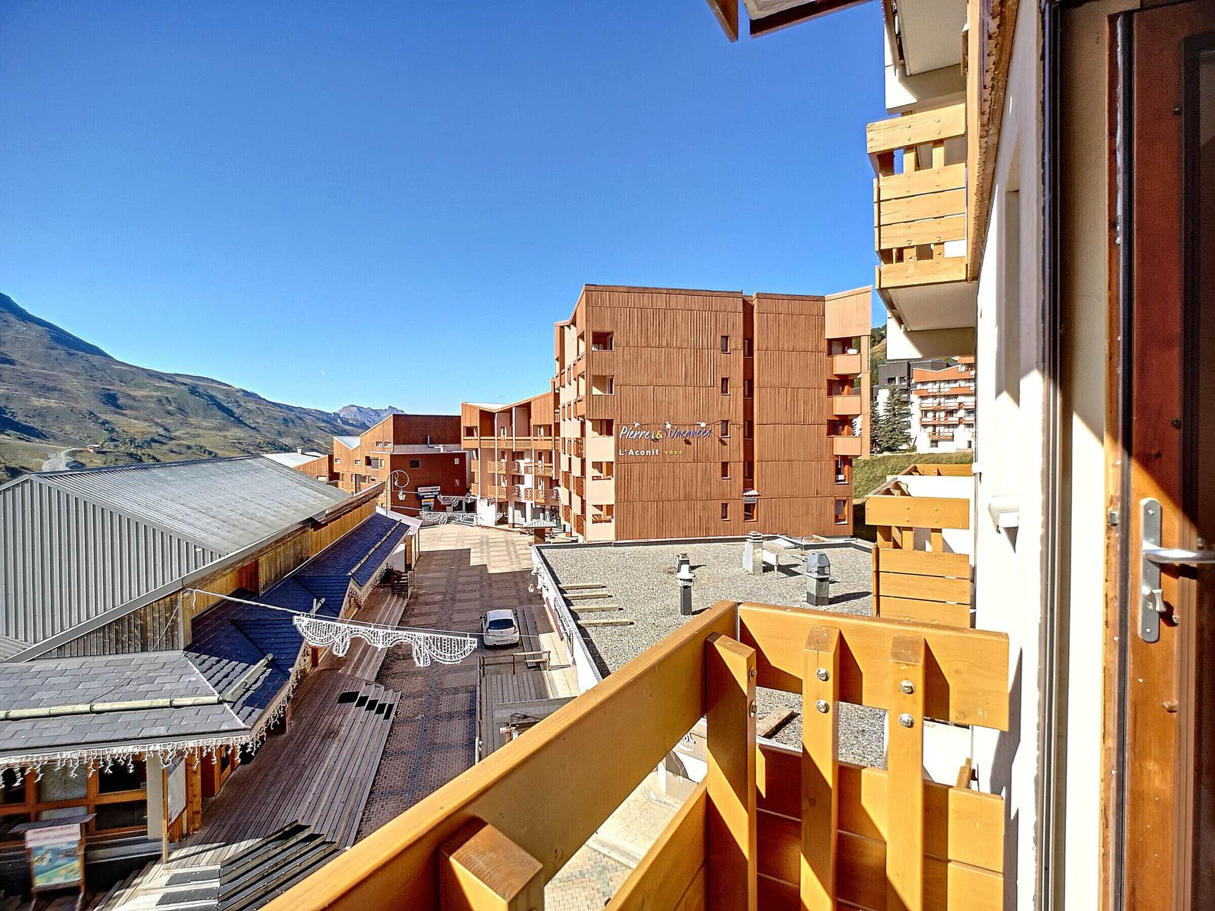A hotel with a modern design, featuring multiple balconies and a view of the surrounding landscape.