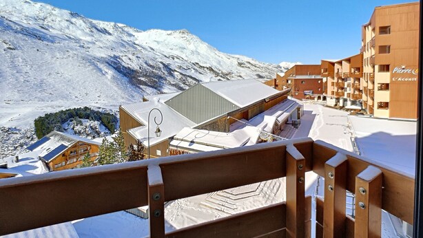 A snow-covered mountain with a ski resort in the background.