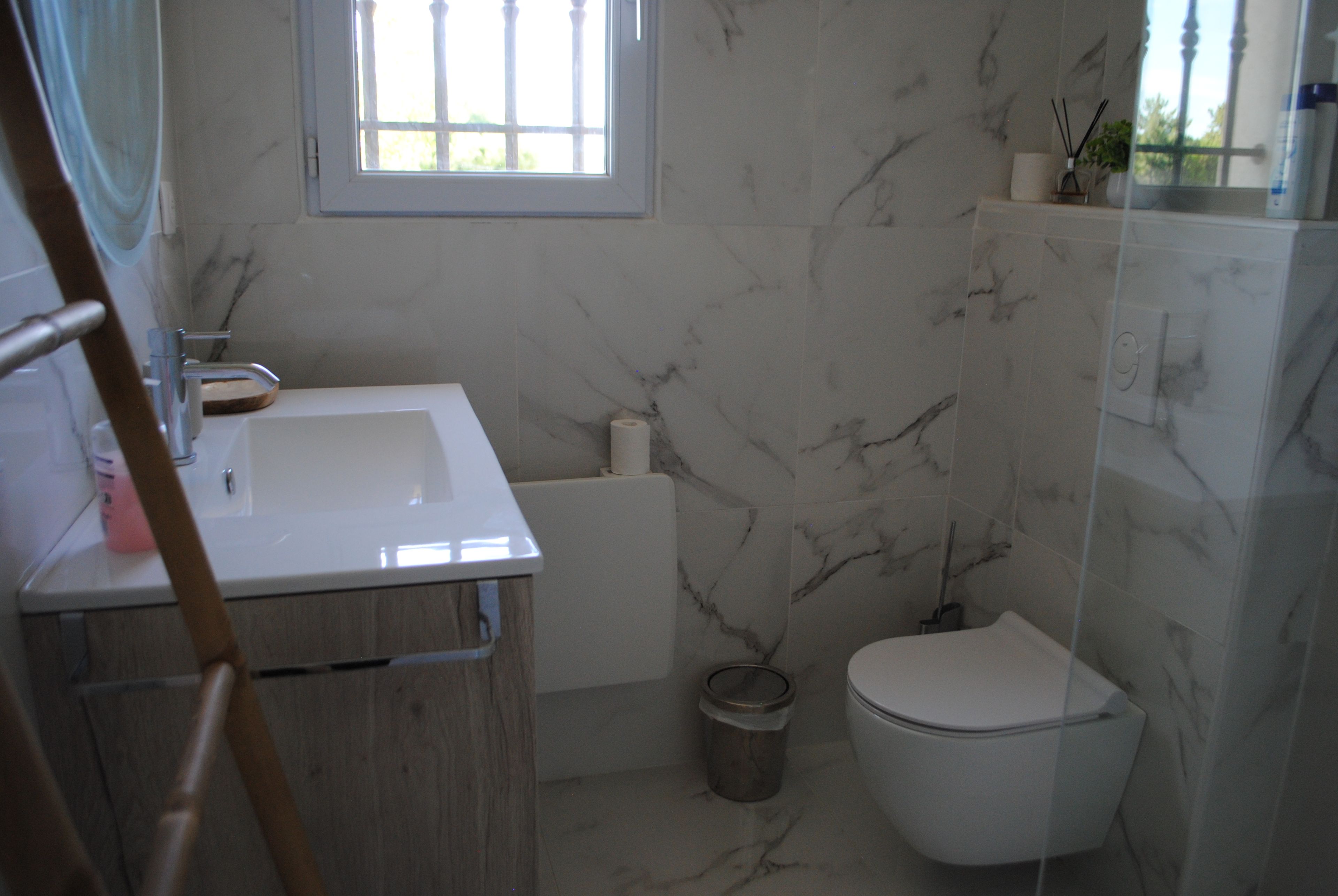 A bathroom with a white sink, a toilet, and a shower area.
