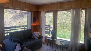 A cozy room with a wooden interior, a sofa, a small table, and a TV.