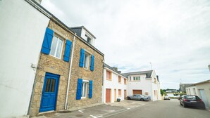 A narrow street with stone buildings, a blue door, and parked cars. - Holiday house 6 pers. in Etel, beach at 100 m (Étel)