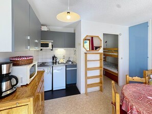 A compact kitchen with a microwave, toaster, and kettle, a wooden ladder, and a bunk bed with a mirror. - Studio cabin 4 pers, Les Menuires, pets allowed (Les Menuires)