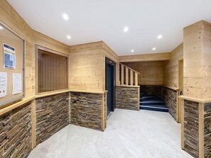 A wooden interior with a stone accent wall, a staircase, and a door.