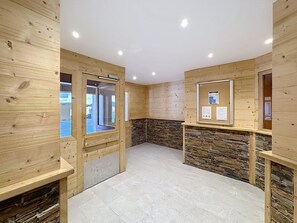 A room with wooden walls, a stone accent wall, and a tiled floor.